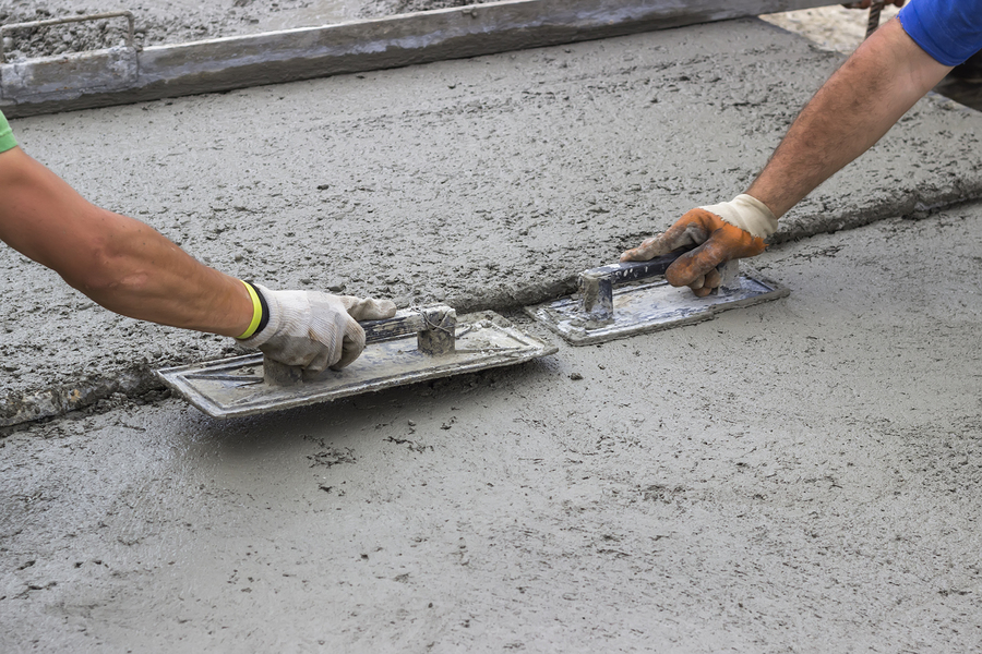 men flattening the concrete cement on the floor